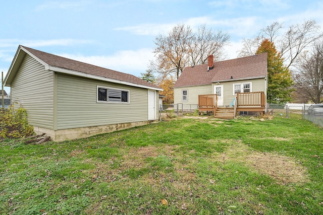 rear view of house featuring a deck and a lawn