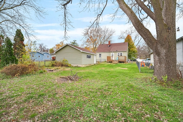 rear view of house featuring a yard and a wooden deck