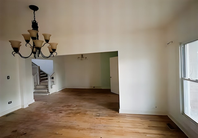 unfurnished living room featuring light hardwood / wood-style flooring and a notable chandelier