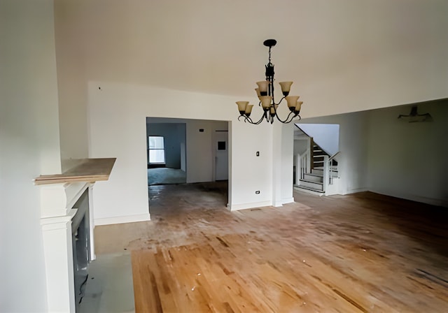 unfurnished living room featuring a chandelier and hardwood / wood-style flooring