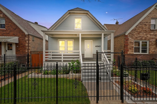 bungalow-style home with a porch and a yard