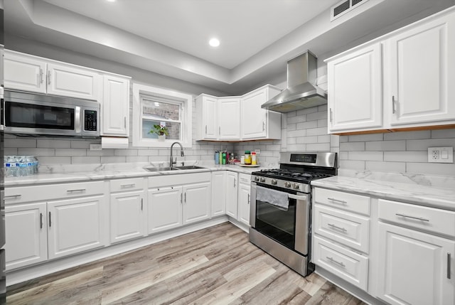 kitchen featuring white cabinets, sink, wall chimney exhaust hood, and stainless steel appliances