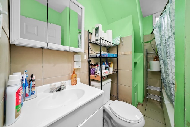 bathroom featuring tile patterned flooring, vanity, toilet, and tile walls