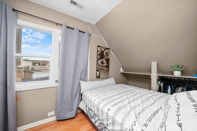 bedroom featuring lofted ceiling and wood-type flooring