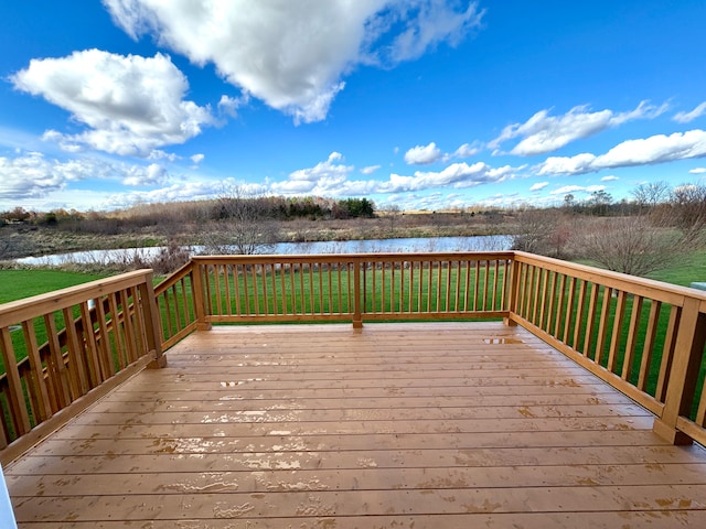 wooden deck with a lawn and a water view