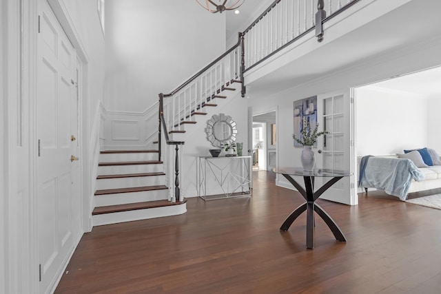 foyer with ornamental molding and dark hardwood / wood-style floors