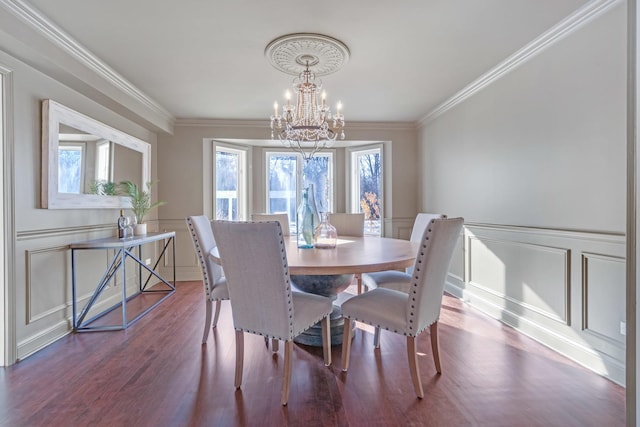 dining space featuring an inviting chandelier, hardwood / wood-style floors, and crown molding