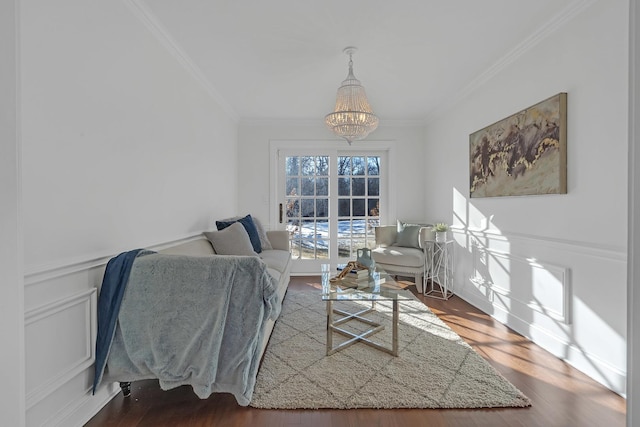 living room featuring crown molding, a chandelier, and hardwood / wood-style flooring