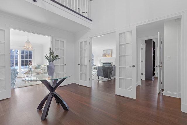 interior space with dark hardwood / wood-style flooring, built in shelves, and french doors