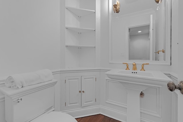 bathroom featuring crown molding, toilet, and hardwood / wood-style flooring