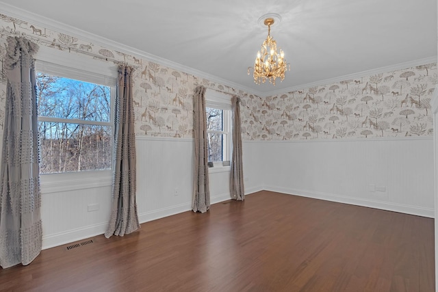 unfurnished room with an inviting chandelier, dark hardwood / wood-style flooring, and ornamental molding