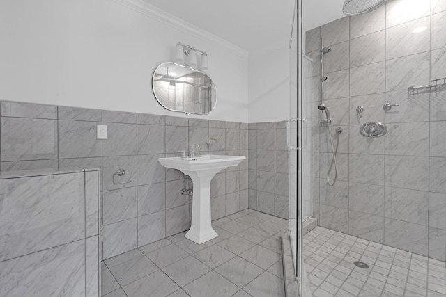 bathroom featuring crown molding, a shower with door, and tile walls