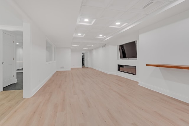 unfurnished living room with coffered ceiling and light hardwood / wood-style floors