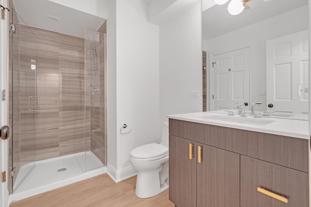 bathroom featuring vanity, an enclosed shower, wood-type flooring, and toilet