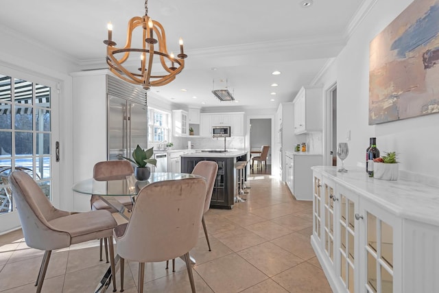 tiled dining area with crown molding and an inviting chandelier