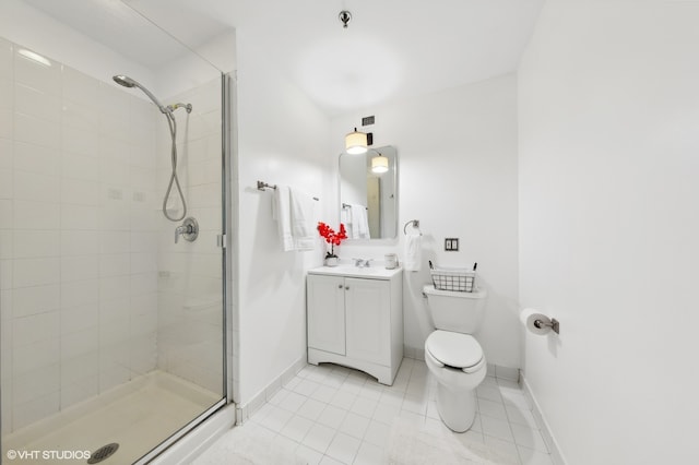 bathroom featuring tile patterned floors, vanity, an enclosed shower, and toilet