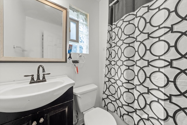 bathroom with walk in shower, vanity, and toilet