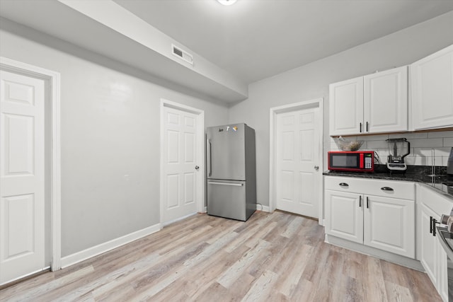 kitchen with stainless steel fridge, backsplash, light hardwood / wood-style flooring, and white cabinetry