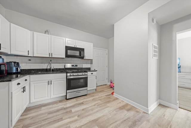 kitchen featuring light wood-type flooring, white cabinetry, stainless steel stove, and tasteful backsplash