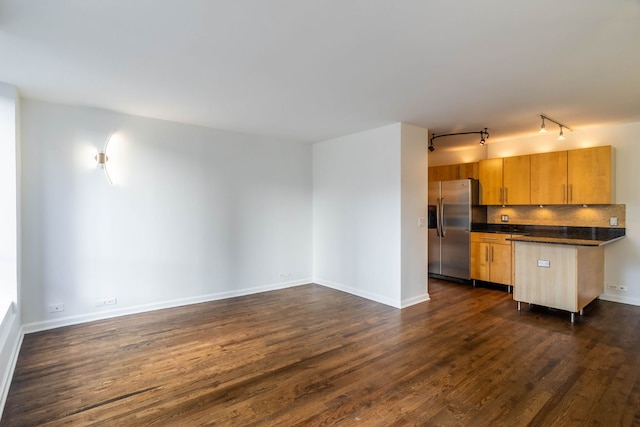 kitchen with rail lighting, dark hardwood / wood-style floors, stainless steel fridge, light brown cabinetry, and tasteful backsplash