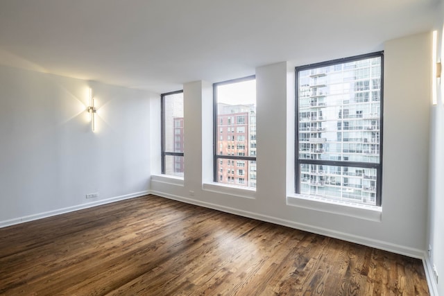 unfurnished room with dark wood-type flooring