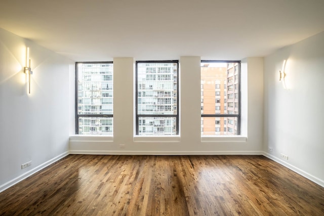 spare room with hardwood / wood-style floors and plenty of natural light