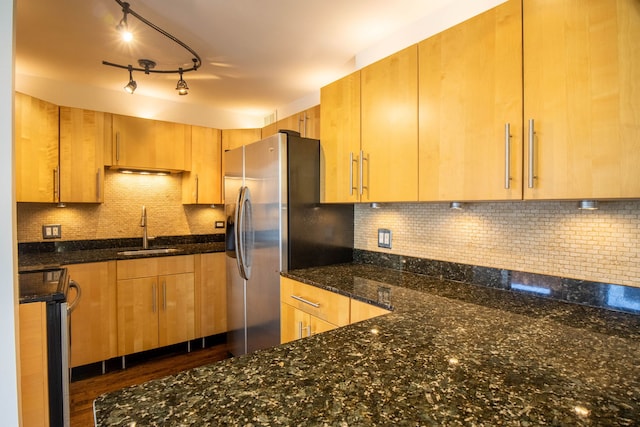 kitchen with backsplash, sink, dark stone countertops, appliances with stainless steel finishes, and dark hardwood / wood-style flooring