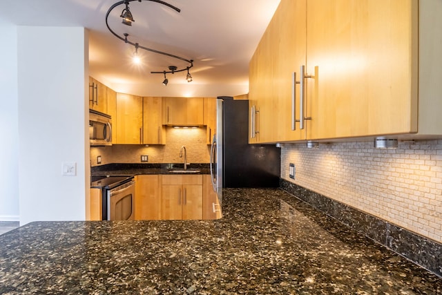 kitchen with dark stone countertops, sink, appliances with stainless steel finishes, and tasteful backsplash