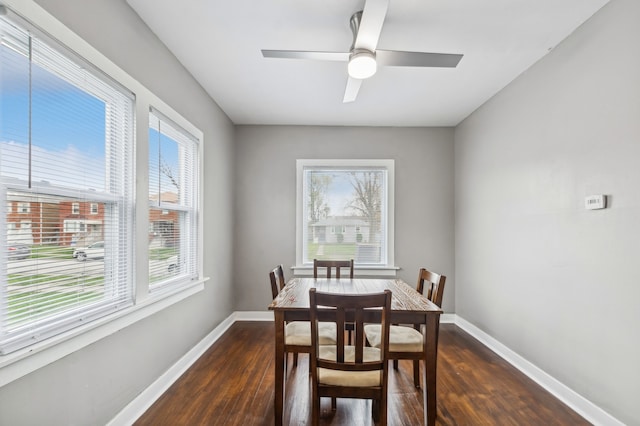 dining room with dark wood-type flooring, ceiling fan, and a healthy amount of sunlight