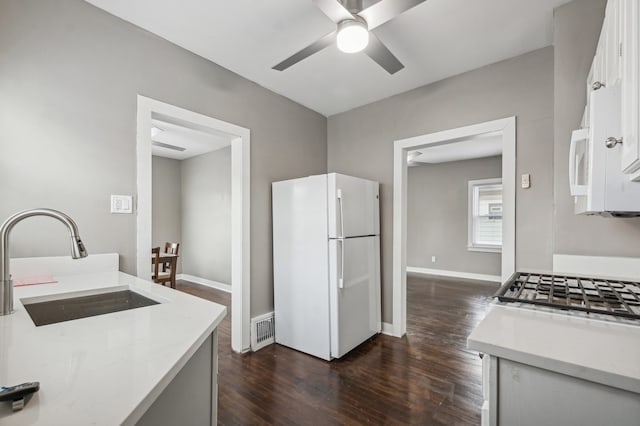 kitchen with white cabinets, sink, dark hardwood / wood-style floors, ceiling fan, and white fridge