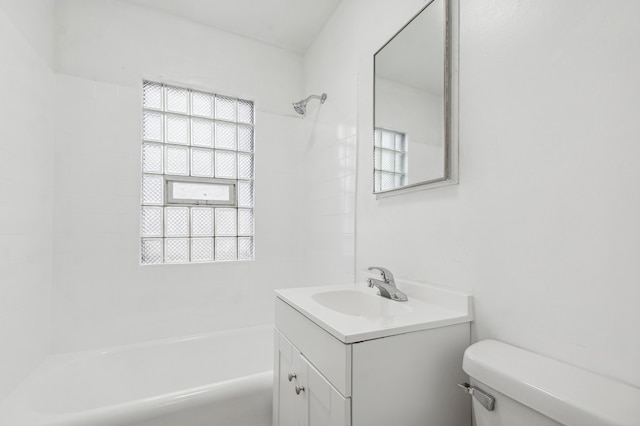 full bathroom featuring tiled shower / bath, vanity, and toilet