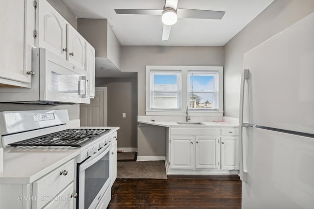 kitchen featuring ceiling fan, sink, dark hardwood / wood-style floors, white appliances, and white cabinets