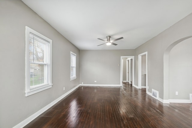 unfurnished room with dark hardwood / wood-style floors, a wealth of natural light, and ceiling fan