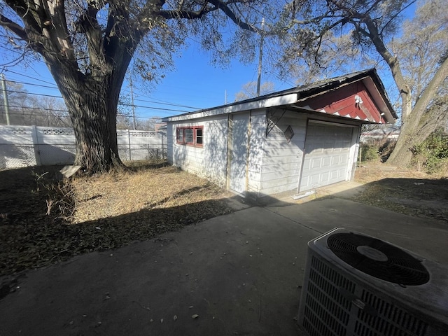 view of side of home with central air condition unit, an outdoor structure, and a garage