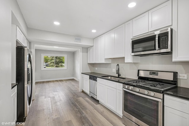 1130 Sandpiper Ct, Bartlett, IL 60103 - kitchen featuring stainless steel appliances, a sink, dark countertops, white cabinetry, and light wood-style floors
