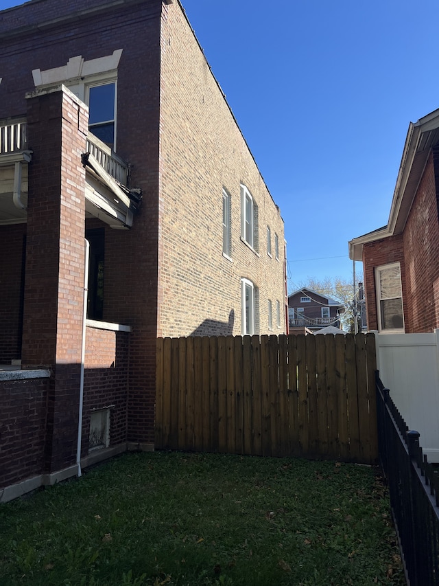 view of home's exterior featuring a yard and a balcony