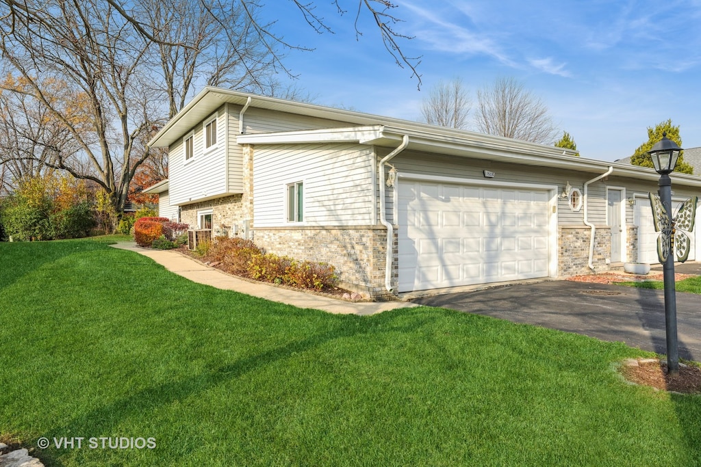 view of side of home featuring a lawn and a garage