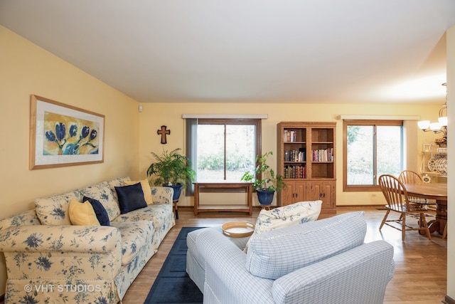 living room featuring hardwood / wood-style flooring, a notable chandelier, and a healthy amount of sunlight