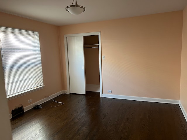 unfurnished bedroom with a closet and dark hardwood / wood-style floors