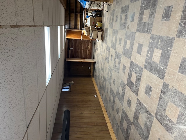 hall with dark hardwood / wood-style flooring and tile walls