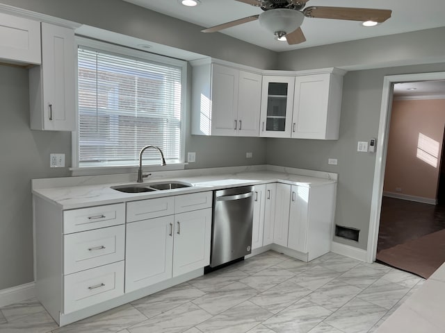 kitchen with white cabinets, sink, stainless steel dishwasher, ceiling fan, and light stone counters