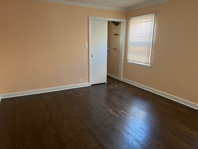 spare room with dark hardwood / wood-style flooring and ornamental molding