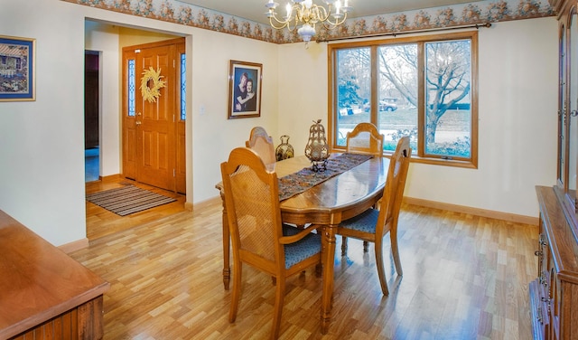 dining space with a chandelier and light hardwood / wood-style flooring