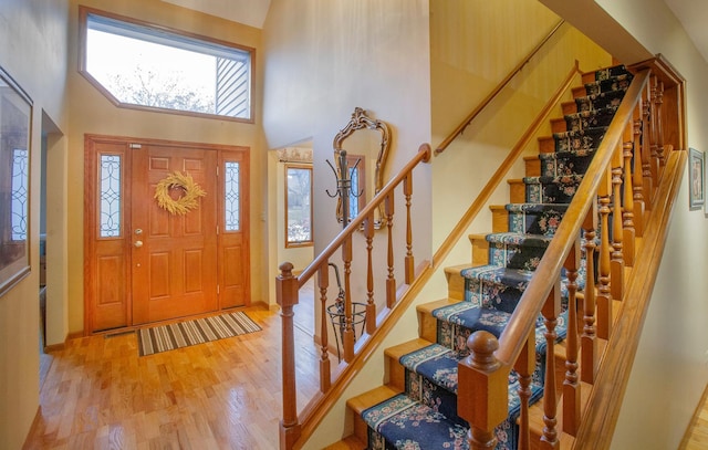 foyer entrance featuring hardwood / wood-style flooring and a towering ceiling