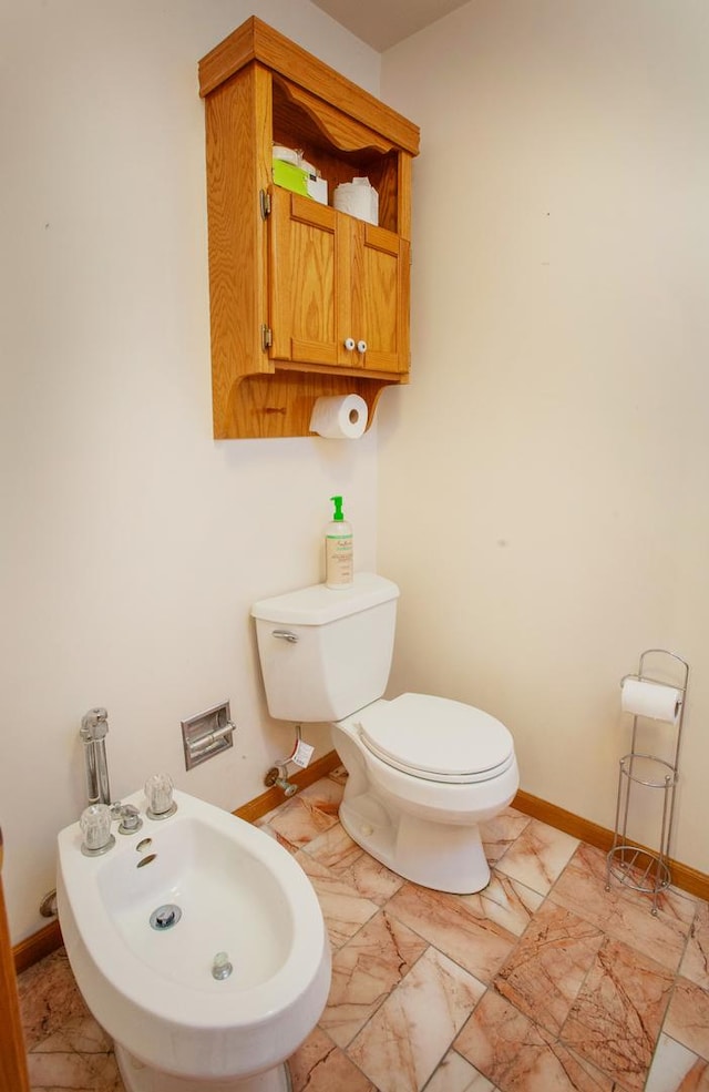 bathroom featuring toilet and a bidet