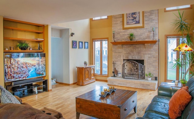 living room featuring a brick fireplace and light wood-type flooring