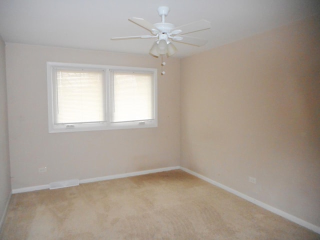 empty room with ceiling fan and light carpet