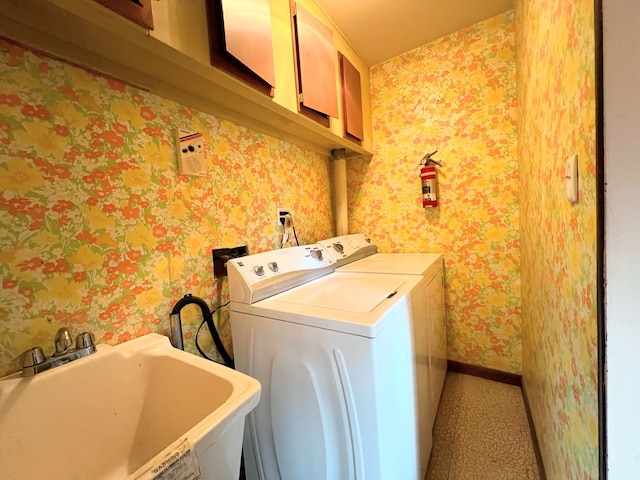 laundry area with washing machine and dryer, sink, and cabinets