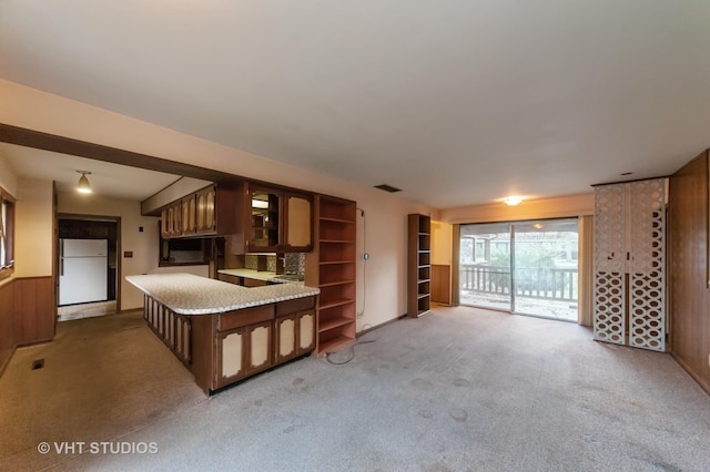 kitchen featuring wood walls, carpet, and white fridge