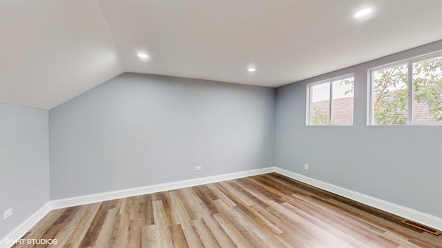 unfurnished room featuring light hardwood / wood-style floors and lofted ceiling